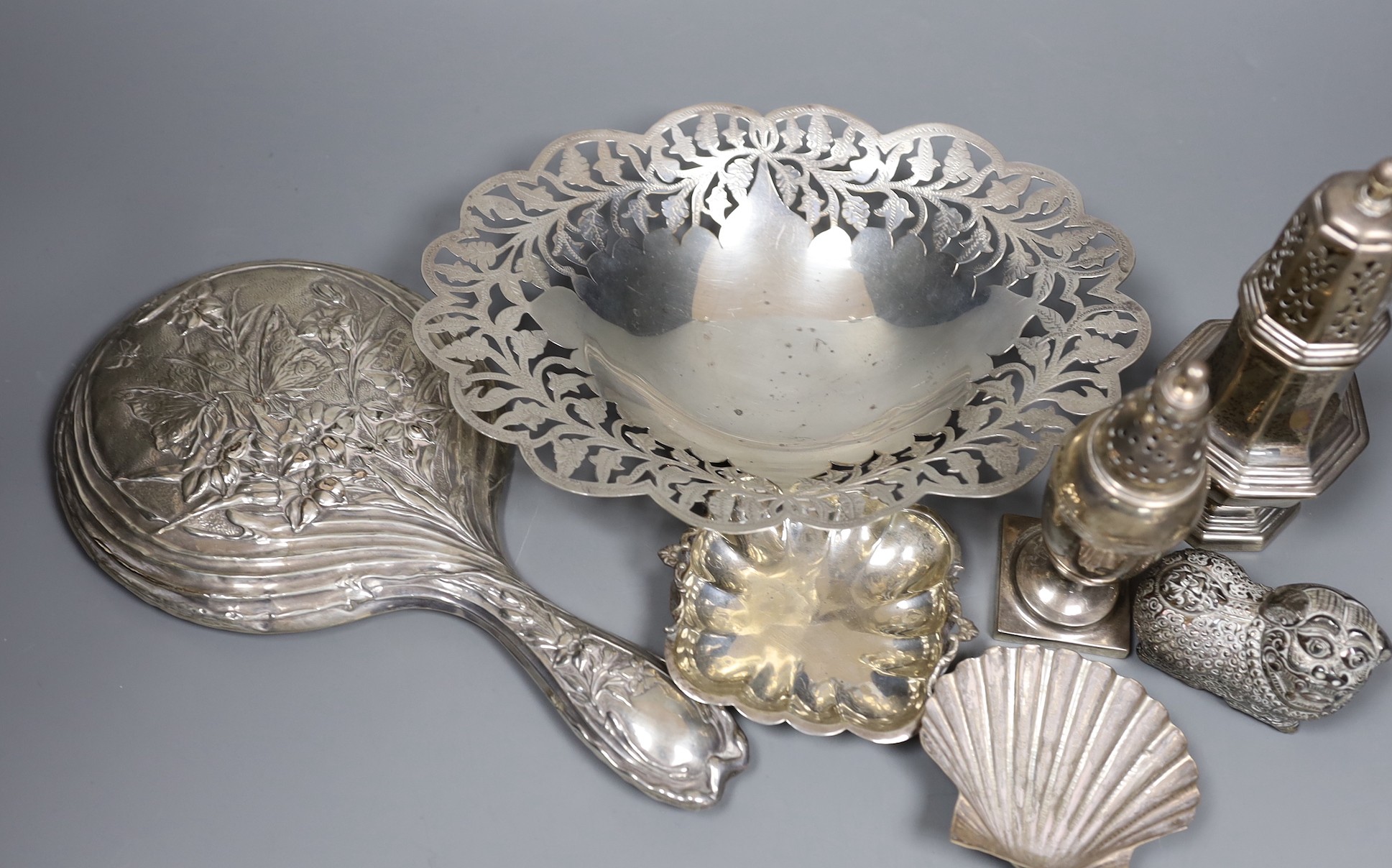 Mixed silver and white metal items including two silver casters, a silver mounted hand mirror, an Egyptian pierced dish, two small dishes and a lion box and cover.